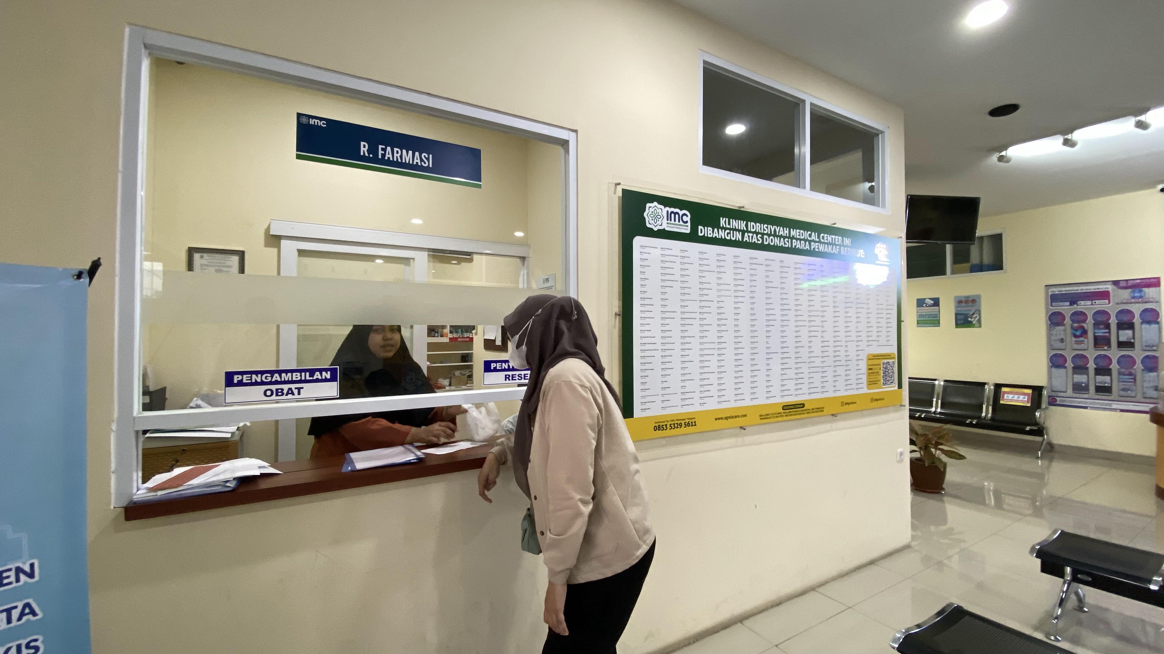 Apotek IMC dengan rak obat lengkap dan apoteker profesional siap melayani